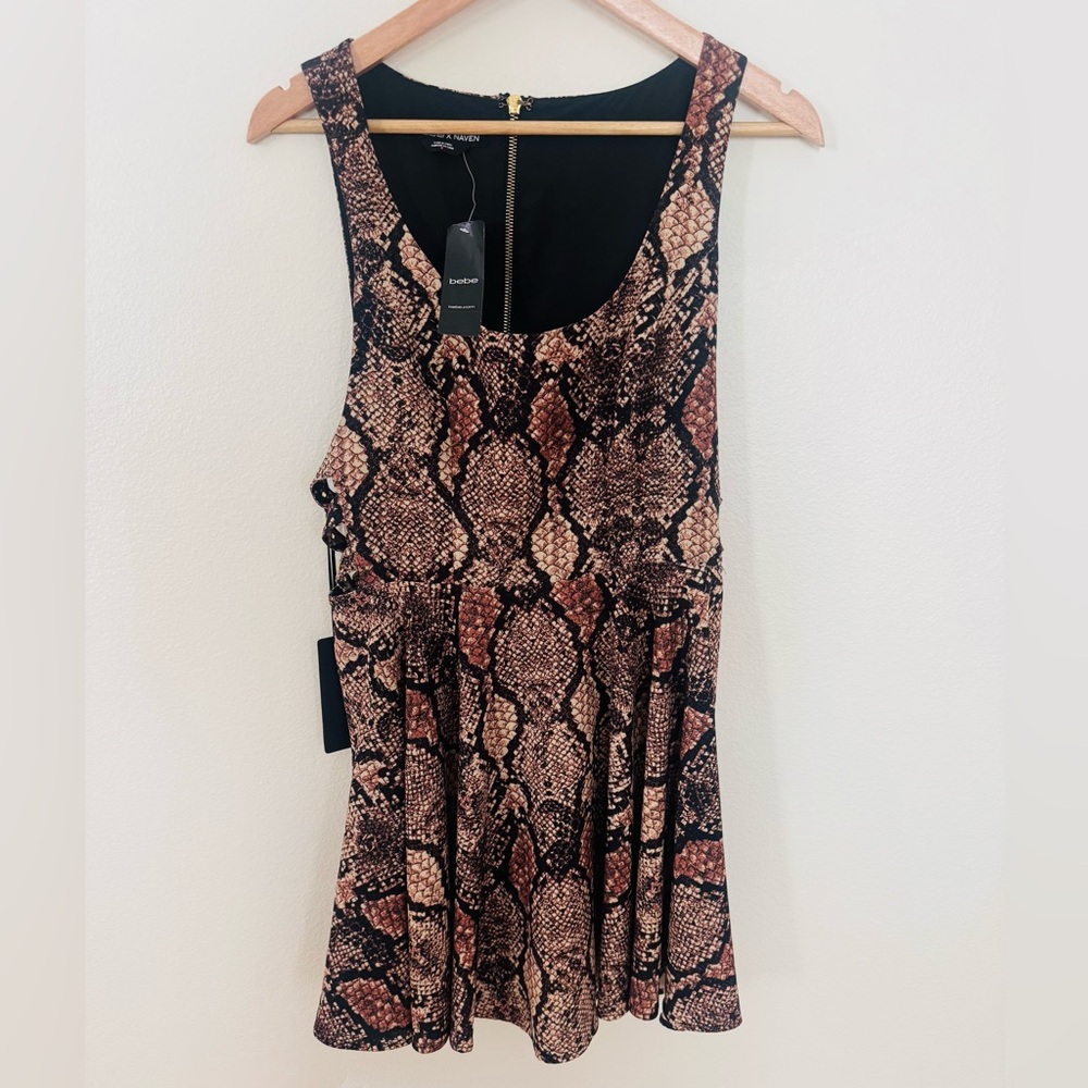 Stunning sexy Bebe snake print dress with buckles on open side. Never worn.